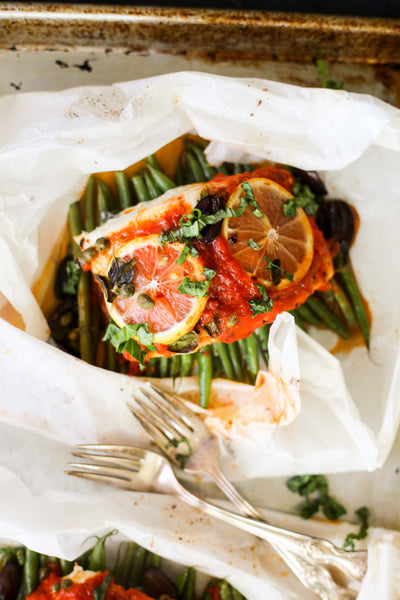 Wild cod Puttanesca en Papillote served with Almond roasted Green Beans